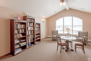 A room with a table and chairs and a bookshelf with books